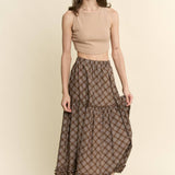 an earthy brown check midi skirt with an elastic waist, flowy tiered silhouette and feminine ruffle trim. available in sizes small through 3xl.
