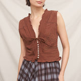 rust brown sleeveless embroidered blouse with v-neck tie, pintuck details, ruffled trim and button front