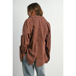 woman wearing an oversized rust brown micro check button-down shirt with long sleeves and buttoned back split detail
