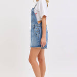 medium wash denim shortalls with square neckline
women's denim overalls shorts with side buttons
relaxed fit cotton denim shortalls
classic blue jean shortalls for women
summer denim overalls styled with white tank top
medium wash denim romper overalls with pockets
casual cotton shortalls for summer
vintage inspired denim shortalls with adjustable straps
