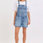 medium wash denim shortalls with square neckline
women's denim overalls shorts with side buttons
relaxed fit cotton denim shortalls
classic blue jean shortalls for women
summer denim overalls styled with white tank top
medium wash denim romper overalls with pockets
casual cotton shortalls for summer
vintage inspired denim shortalls with adjustable straps