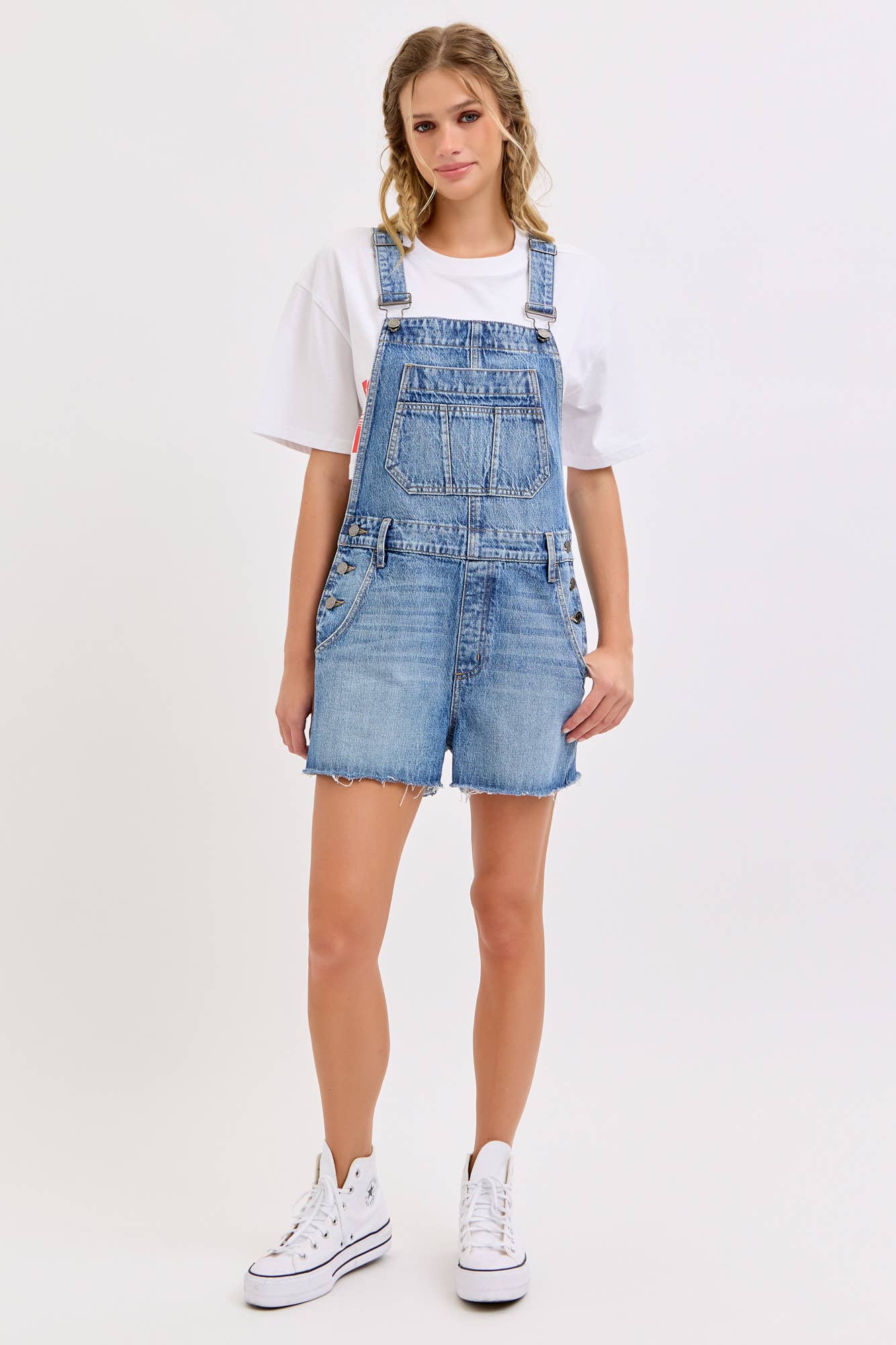 medium wash denim shortalls with square neckline
women's denim overalls shorts with side buttons
relaxed fit cotton denim shortalls
classic blue jean shortalls for women
summer denim overalls styled with white tank top
medium wash denim romper overalls with pockets
casual cotton shortalls for summer
vintage inspired denim shortalls with adjustable straps