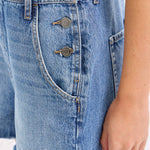 medium wash denim shortalls with square neckline
women's denim overalls shorts with side buttons
relaxed fit cotton denim shortalls
classic blue jean shortalls for women
summer denim overalls styled with white tank top
medium wash denim romper overalls with pockets
casual cotton shortalls for summer
vintage inspired denim shortalls with adjustable straps