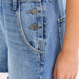 medium wash denim shortalls with square neckline
women's denim overalls shorts with side buttons
relaxed fit cotton denim shortalls
classic blue jean shortalls for women
summer denim overalls styled with white tank top
medium wash denim romper overalls with pockets
casual cotton shortalls for summer
vintage inspired denim shortalls with adjustable straps