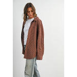 woman wearing an oversized rust brown micro check button-down shirt with long sleeves and buttoned back split detail