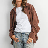 woman wearing an oversized rust brown micro check button-down shirt with long sleeves and buttoned back split detail