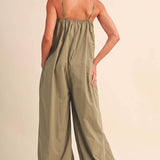 olive green jumpsuit, cotton wide leg jumpsuit, balloon hem jumpsuit, relaxed fit one piece outfit, casual summer jumpsuit, spaghetti strap jumpsuit, oversized cotton jumpsuit, boho green jumpsuit, jumpsuit with pockets, comfortable travel outfit