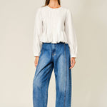 women's white button front blouse with pintuck pleats, long puff sleeves, round neckline, and ruffled babydoll hem