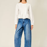 women's white button front blouse with pintuck pleats, long puff sleeves, round neckline, and ruffled babydoll hem