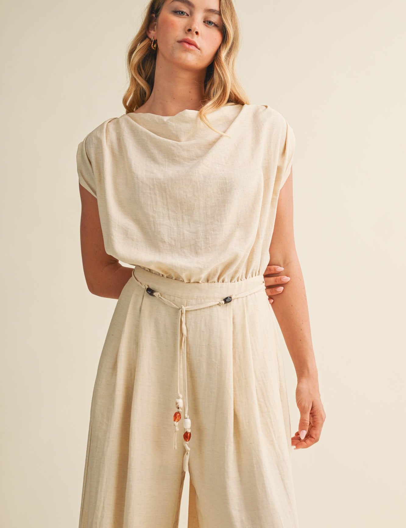 ream wide leg jumpsuit, cowl neck jumpsuit, linen blend jumpsuit, neutral one piece outfit, drawstring waist jumpsuit, resort wear jumpsuit, cap sleeve jumpsuit, flowy wide leg romper, elegant casual jumpsuit, women's cream jumpsuit