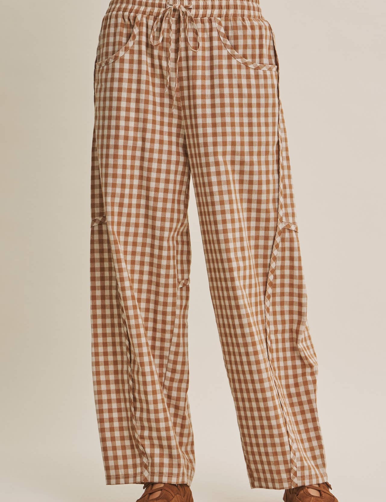 relaxed brown and cream gingham barrel pants in 100% cotton with an elastic drawstring waist, curved seaming and oversized pockets.