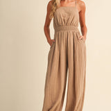 linen blend jumpsuit, tan jumpsuit women, bow back jumpsuit, smocked waist jumpsuit, square neck jumpsuit, relaxed fit one piece outfit, boho jumpsuit, wide leg jumpsuit, neutral summer jumpsuit, lightweight vacation outfit