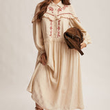 cream embroidered maxi dress with rust floral detailing, ruffled yoke, long puff sleeves and button front