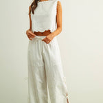 embroidered cotton linen sleeveless top with side ties
white embroidered tank top with relaxed boxy fit
cotton linen sleeveless blouse with tie side detail
lightweight embroidered summer top in white
relaxed fit cotton linen tank with embroidery
white sleeveless top paired with matching linen pants
breathable cotton linen blouse for summer
embroidered neutral top with hip length silhouette
bridal outfit
honeymoon outfit