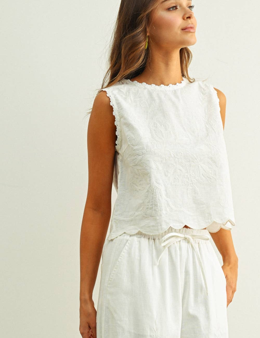 embroidered cotton linen sleeveless top with side ties
white embroidered tank top with relaxed boxy fit
cotton linen sleeveless blouse with tie side detail
lightweight embroidered summer top in white
relaxed fit cotton linen tank with embroidery
white sleeveless top paired with matching linen pants
breathable cotton linen blouse for summer
embroidered neutral top with hip length silhouette
bridal outfit
bachelorette outfit
honeymoon outfit