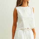 embroidered cotton linen sleeveless top with side ties
white embroidered tank top with relaxed boxy fit
cotton linen sleeveless blouse with tie side detail
lightweight embroidered summer top in white
relaxed fit cotton linen tank with embroidery
white sleeveless top paired with matching linen pants
breathable cotton linen blouse for summer
embroidered neutral top with hip length silhouette
bridal outfit
bachelorette outfit
honeymoon outfit