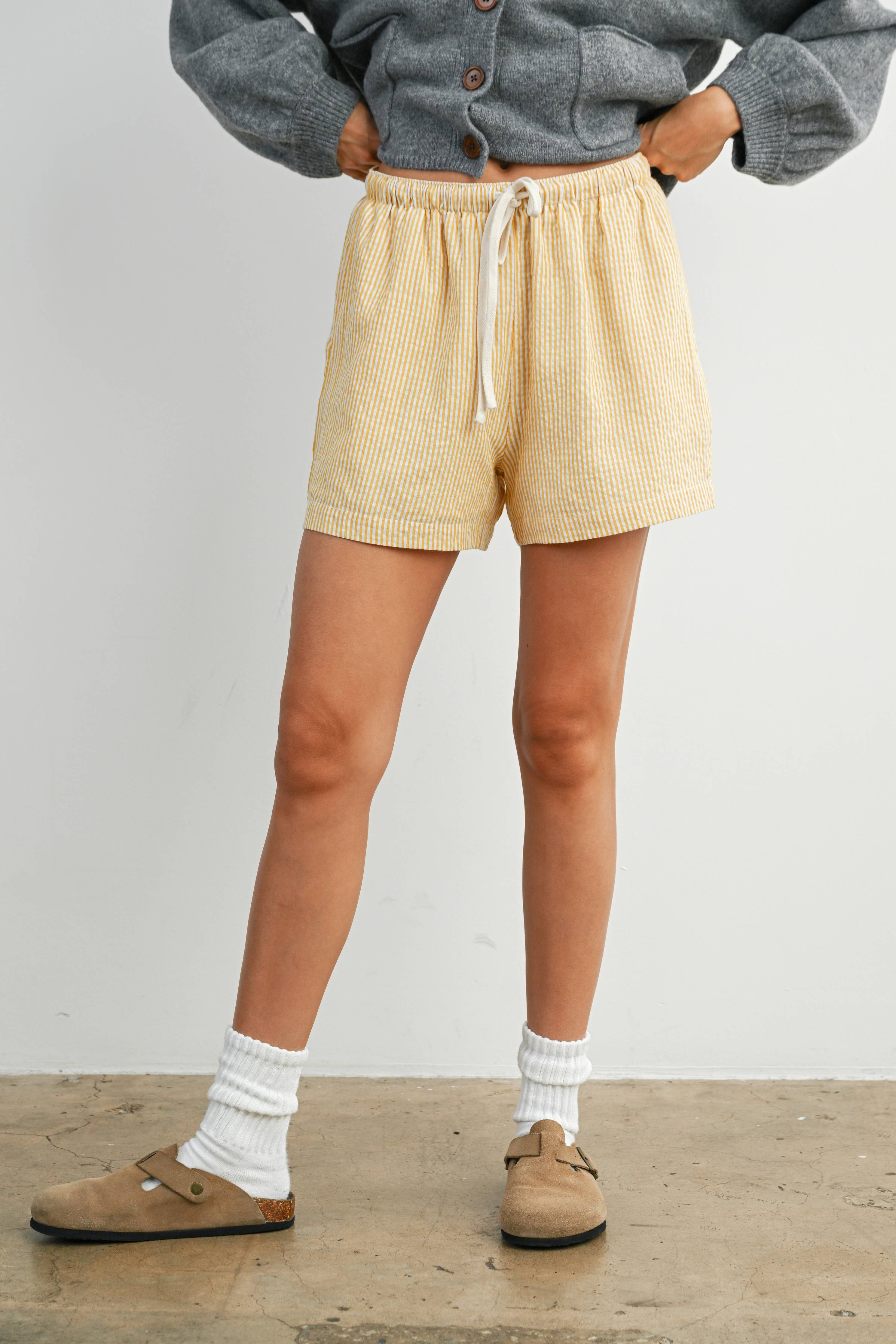 yellow striped drawstring shorts
coastal summer shorts women
lightweight vacation shorts
relaxed striped lounge shorts
elastic waist casual shorts women
resort wear boutique shorts
beach vacation outfit women
casual coastal style shorts
summer drawstring shorts women
west of may spritz collection