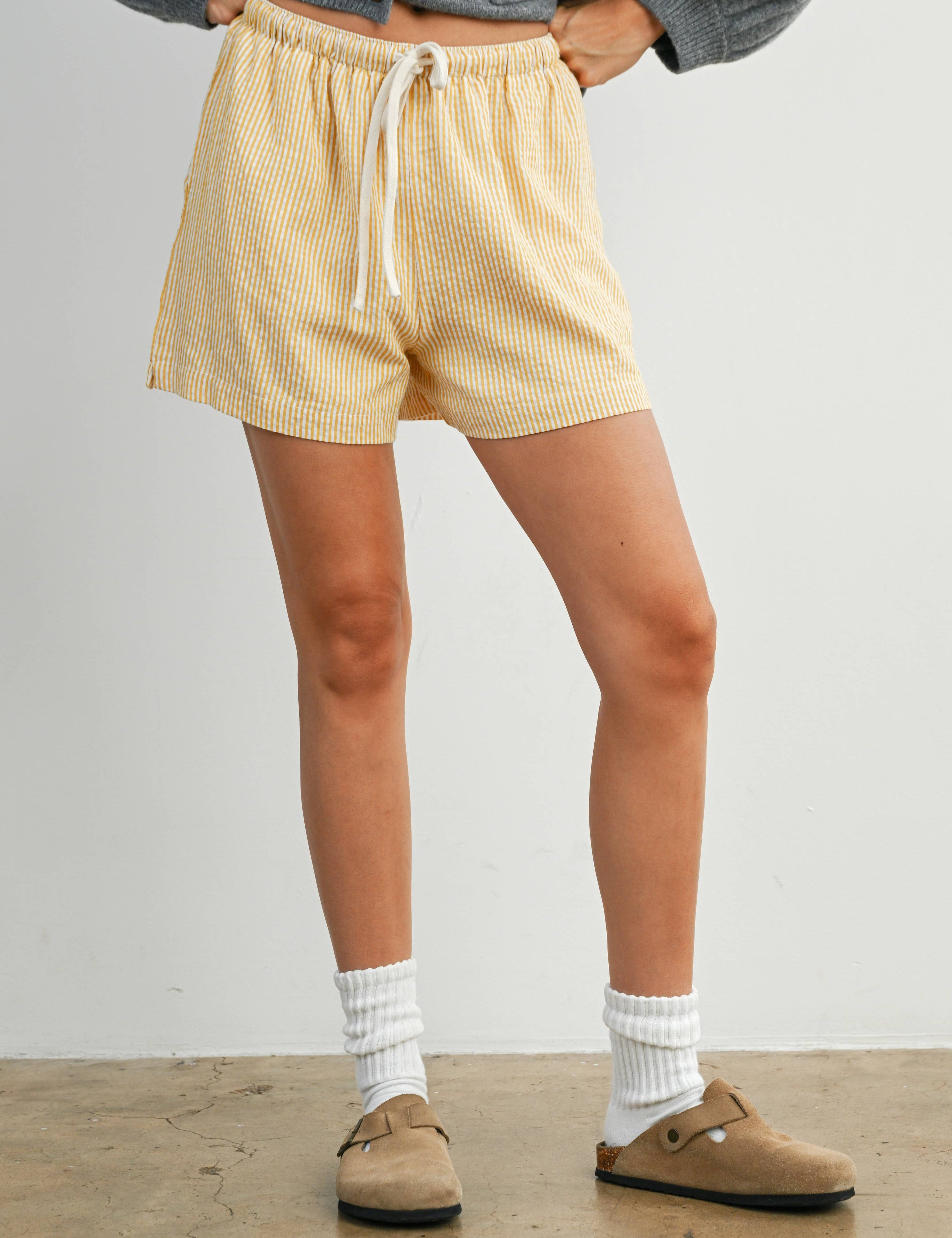 yellow striped drawstring shorts
coastal summer shorts women
lightweight vacation shorts
relaxed striped lounge shorts
elastic waist casual shorts women
resort wear boutique shorts
beach vacation outfit women
casual coastal style shorts
summer drawstring shorts women
west of may spritz collection