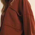 oversized button-up sweatshirt, cotton button-up sweatshirt, oversized cotton top, rust sweatshirt, exposed seam sweatshirt, relaxed fit sweatshirt, lightweight sweatshirt jacket, fall layering top, casual women's sweatshirt, boutique fall top, west of may boutique, free people dupe, boho style